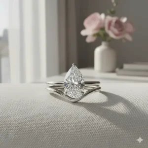 2 carat pear shaped diamond engagement ring paired with a matching contoured wedding band.