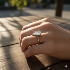 A contemporary East-West pear shaped engagement ring, where the teardrop diamond is set horizontally across the finger for a unique modern style.