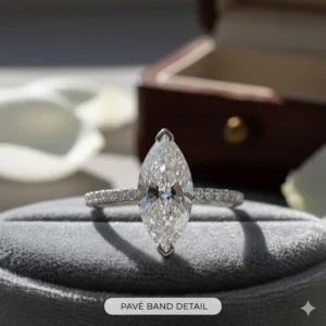 Close-up of a brilliant marquise engagement ring featuring a sparkling pavé diamond band.