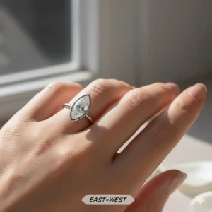 Unique east-west setting for a marquise engagement ring, where the diamond is oriented horizontally across the finger.