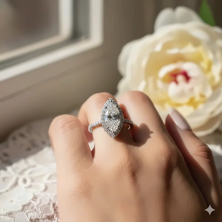 Beautiful marquise halo engagement ring set in white gold on a bride-to-be's hand, showing the elongated diamond shape and shimmering halo setting.