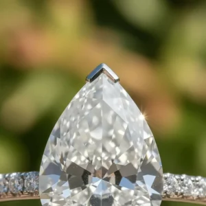 Detailed close-up of a pear-cut diamond showing the protective prong setting at the pointed tip of the stone.
