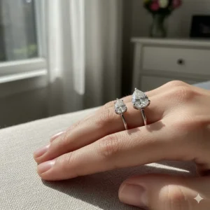 Visual comparison of a 1 carat versus a 2 carat pear shaped diamond ring on a finger.