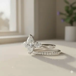 Matching three stone marquise engagement ring paired with a simple diamond wedding band.