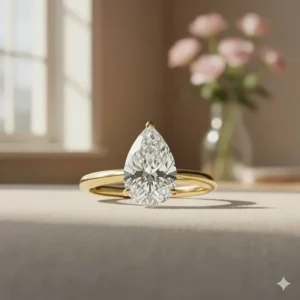 Beautiful 2 carat pear shaped diamond ring featuring a yellow gold band and setting.