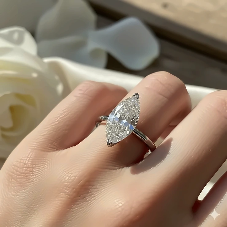 A striking marquise cut diamond engagement ring set in a classic solitaire style on a white gold band, showcasing the elegant, elongated shape of the stone.