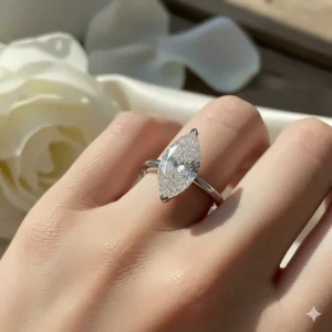 Elegant photograph of a marquise cut engagement ring worn on a hand, illustrating how the shape lengthens the finger.