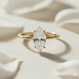 A beautiful marquise solitaire diamond ring featuring a thin yellow gold band, providing a warm contrast to the brilliant-cut diamond.