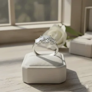 Example of a three-stone ring that mixes diamond cuts, featuring a cushion-cut center stone and two baguette-cut side diamonds.