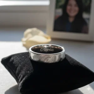A memorial fingerprint engraved ring used as a keepsake to honor a loved one.
