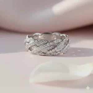 A pavé diamond braided wedding ring in white gold reflecting light on a neutral background.