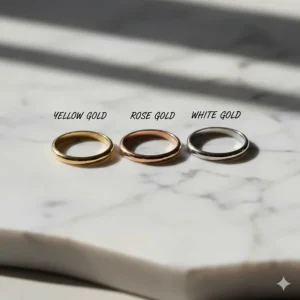 Three delicate thin wedding bands shown in yellow gold, rose gold, and white gold finishes to compare metal colors.