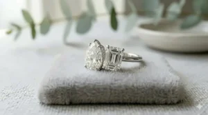 A modern Toi et Moi engagement ring style featuring a pear-shaped diamond paired side-by-side with an emerald-cut diamond on a platinum band.