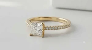 Modern yellow gold princess cut ring with a pavé diamond band
