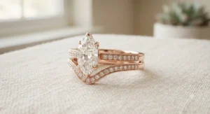 Matching rose gold marquise engagement ring and curved wedding band set styled for modern brides.