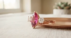 Three-stone rose gold marquise ring featuring a vibrant center stone flanked by sparkling side diamonds.