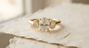 Classic three-stone yellow gold engagement ring featuring an oval center diamond.