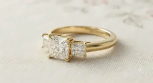 Elegant three-stone yellow gold princess cut ring with tapered side diamonds