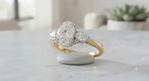 Elegant two-tone oval engagement ring adorned with pear-shaped side stones on a dual-tone band.