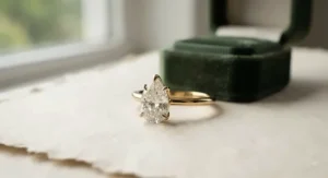 A minimalist pear-shaped diamond solitaire engagement ring set in 14k yellow gold, showcasing a clean and elegant design.