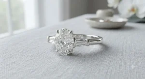 An oval cut diamond engagement ring accented with tapered baguette side stones on a white gold band.
