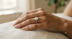 Elegant hand shot of a pear shaped halo engagement ring showing proportional fit and finger coverage.