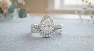 Bridal set featuring a sparkling pear shaped halo engagement ring paired with a curved wedding band.