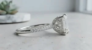 Side profile view of a high set white gold emerald cut diamond ring highlighting the basket setting.