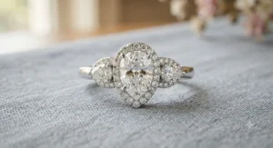 Unique three stone pear shaped halo engagement ring paired with tapered side diamonds.