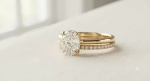 Yellow gold oval diamond engagement ring paired flush with a matching diamond wedding band.