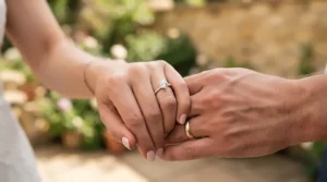 A couple holding hands, highlighting full eternity bands for anniversary gifts on a milestone celebration.